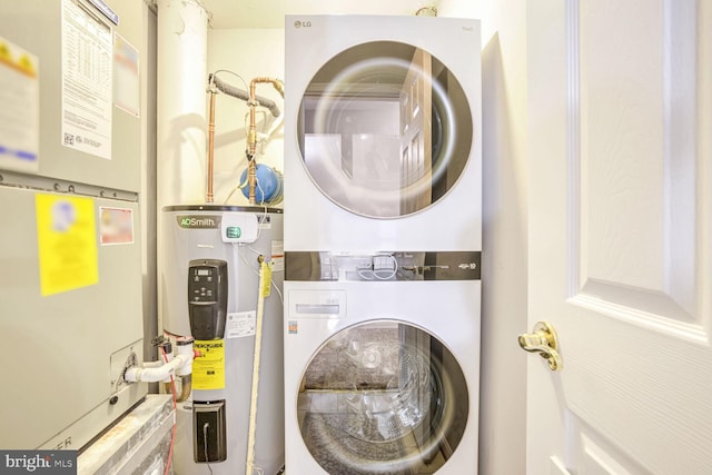 laundry area featuring stacked washer and clothes dryer, heating unit, and electric water heater