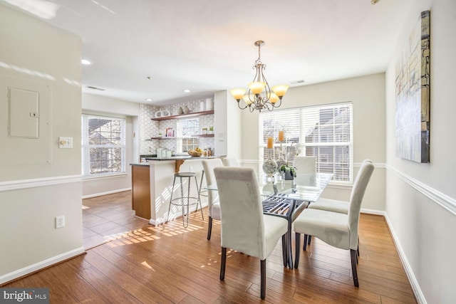 dining space featuring hardwood / wood-style floors and a notable chandelier