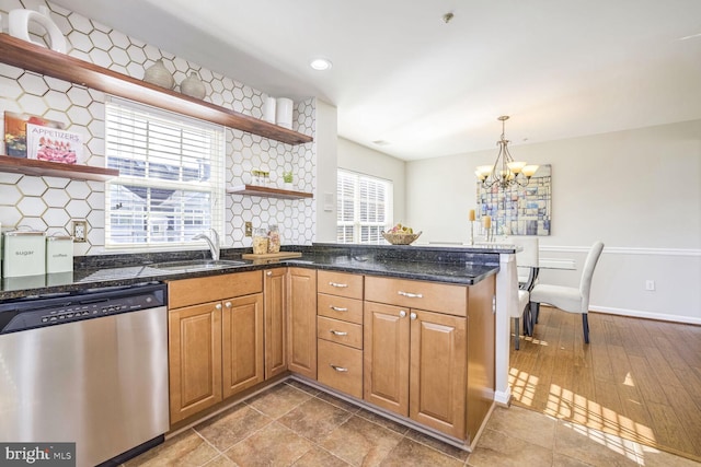 kitchen featuring dishwasher, hardwood / wood-style flooring, sink, and backsplash