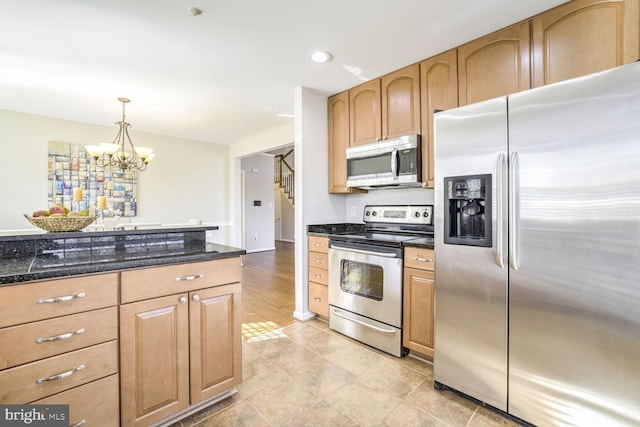 kitchen with stainless steel appliances, an inviting chandelier, hanging light fixtures, and light hardwood / wood-style flooring