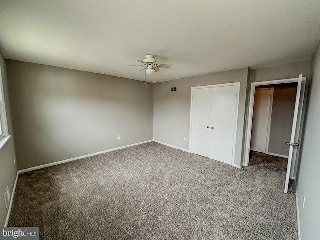 unfurnished room with ceiling fan and carpet