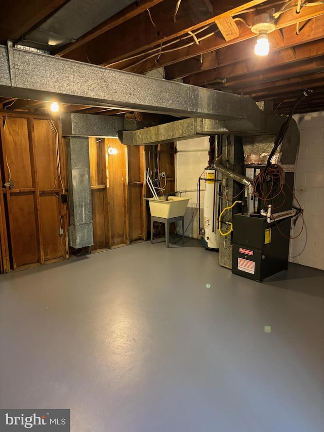 basement featuring heating unit, sink, and gas water heater