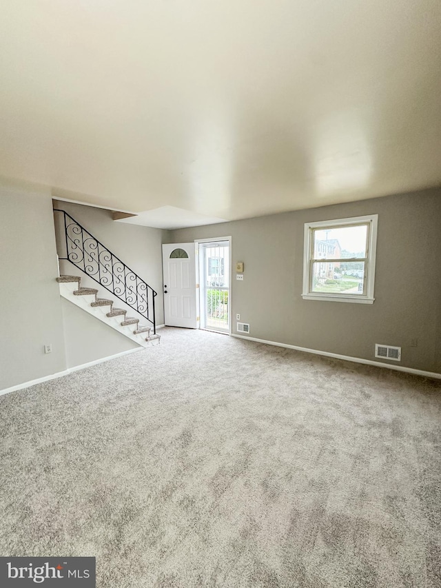 unfurnished living room featuring plenty of natural light and carpet floors