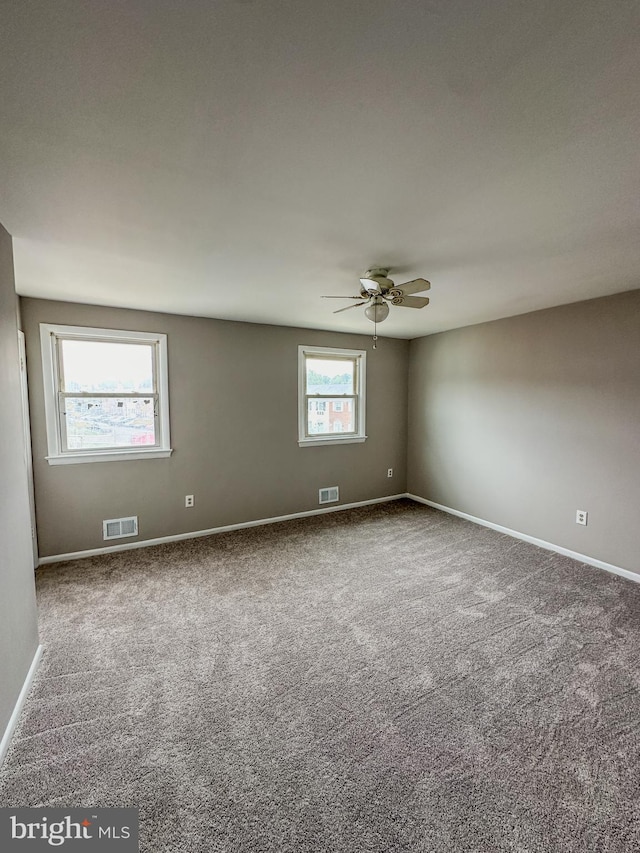 unfurnished room with ceiling fan and carpet