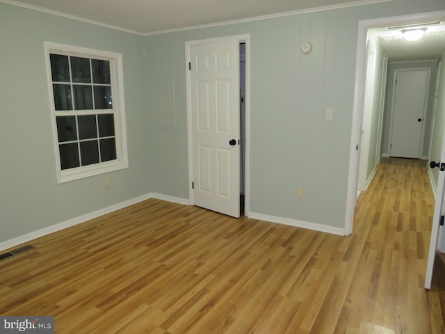 unfurnished room with light hardwood / wood-style floors and crown molding