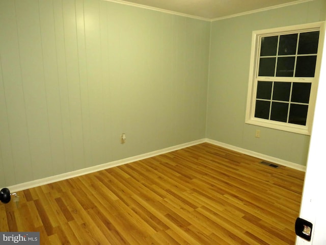 unfurnished room featuring hardwood / wood-style flooring and crown molding