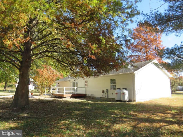 view of property exterior with a lawn and a wooden deck