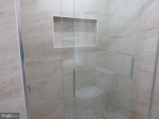 bathroom featuring toilet and a shower with door