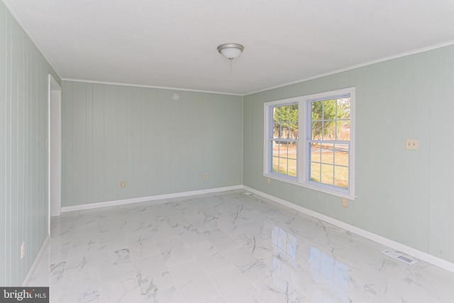 empty room with crown molding and wood walls