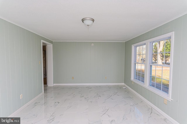 empty room featuring crown molding and wooden walls