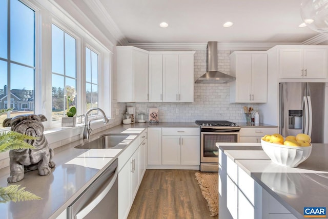 kitchen featuring ornamental molding, stainless steel appliances, white cabinetry, wall chimney range hood, and dark hardwood / wood-style floors