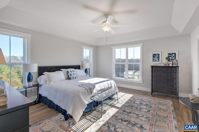 bedroom featuring dark hardwood / wood-style flooring, multiple windows, and ceiling fan