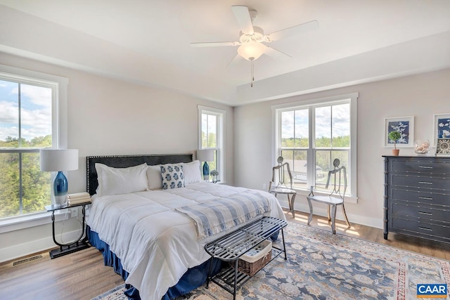 bedroom with multiple windows, ceiling fan, and light hardwood / wood-style flooring