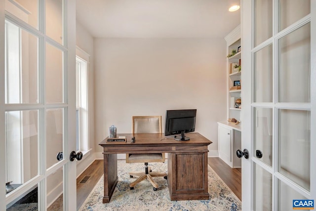 office space featuring built in shelves, wood-type flooring, and french doors