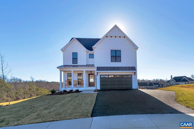 modern inspired farmhouse featuring a garage, a front yard, and a porch