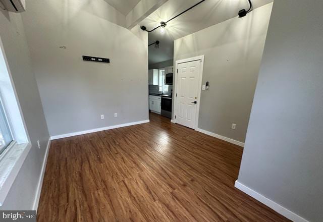 spare room featuring a wall mounted AC and dark hardwood / wood-style flooring