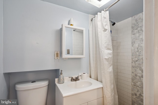 bathroom with vanity, toilet, and curtained shower