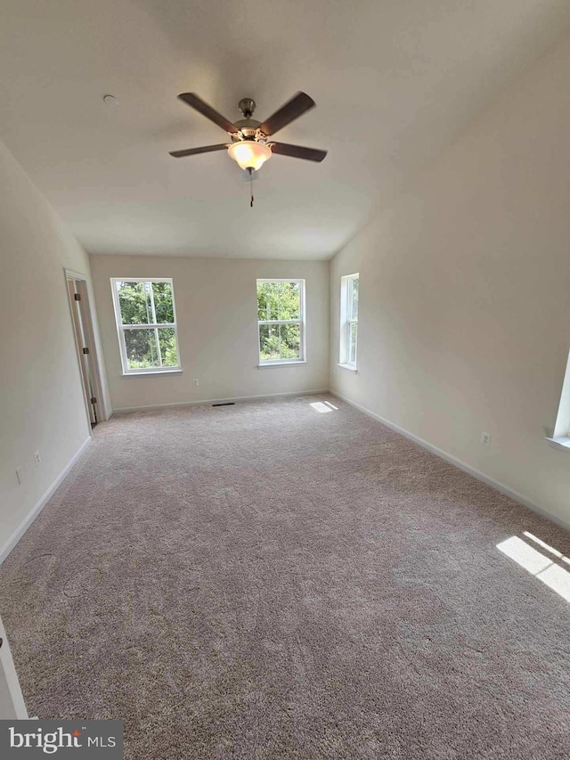 spare room featuring light colored carpet and ceiling fan