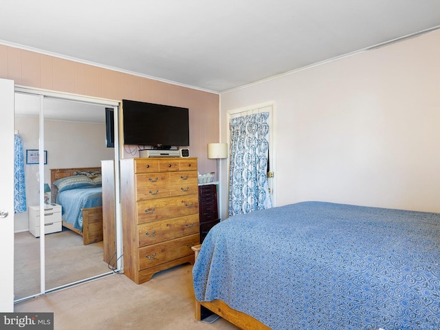 bedroom with carpet floors, ornamental molding, and a closet