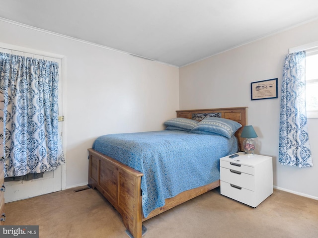 carpeted bedroom featuring baseboards and ornamental molding