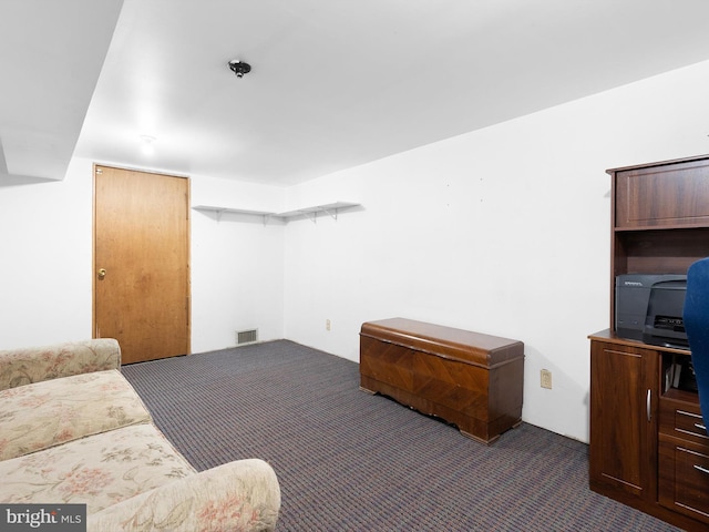 living area featuring dark carpet and visible vents