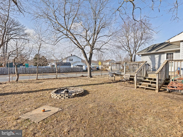 view of yard featuring an outdoor fire pit, fence, and a wooden deck