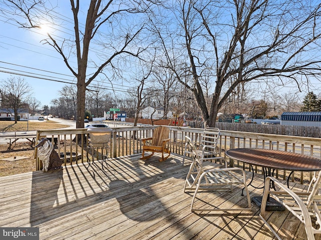 wooden deck with outdoor dining area and fence