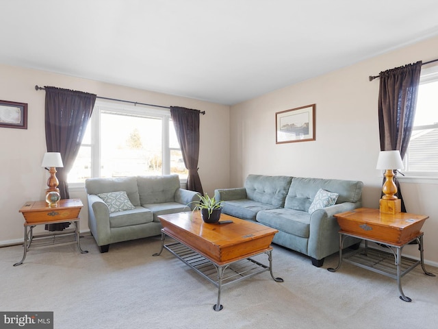 living area featuring light carpet and baseboards