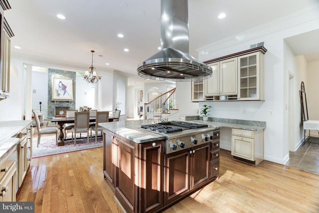 kitchen featuring crown molding, light wood-type flooring, cream cabinets, and island range hood