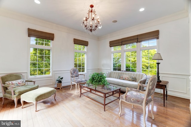 living room featuring a wealth of natural light, light wood-type flooring, and ornamental molding