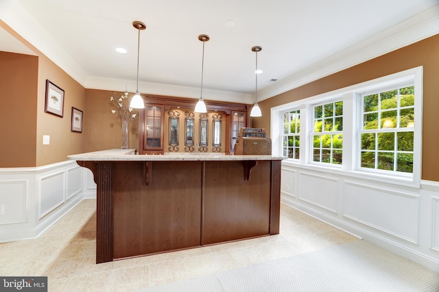 6318 Georgetown Pike, Mclean, VA 22101 - kitchen with a decorative wall, a breakfast bar area, a center island, hanging light fixtures, and crown molding