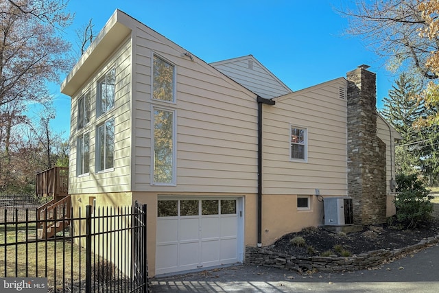 339 Hamilton Ave, Princeton, NJ 08540 - view of side of property featuring an attached garage, fence, a chimney, and central AC unit
