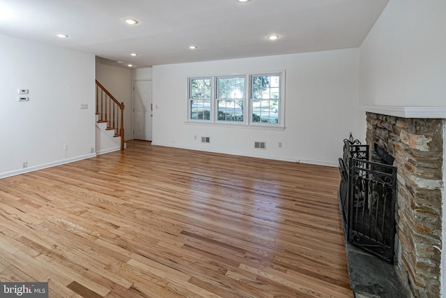 339 Hamilton Ave, Princeton, NJ 08540 - unfurnished living room featuring light wood-style floors, stairway, a stone fireplace, recessed lighting, and baseboards