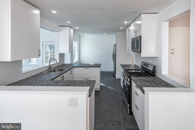 339 Hamilton Ave, Princeton, NJ 08540 - kitchen featuring appliances with stainless steel finishes, a sink, a peninsula, dark tile patterned floors, and white cabinets