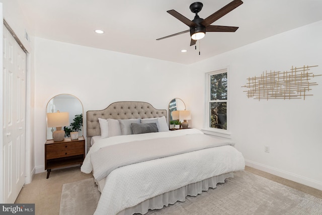 bedroom featuring light carpet, ceiling fan, and a closet