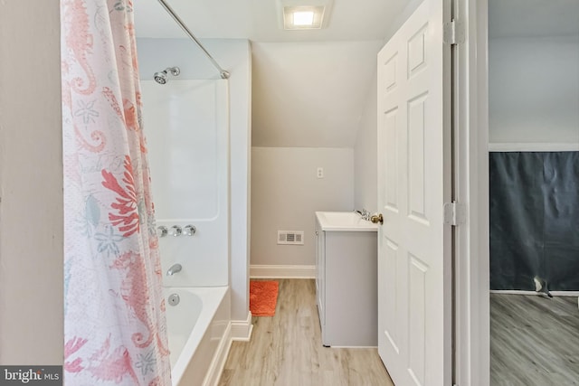 bathroom with wood-type flooring, vanity, shower / bathtub combination with curtain, and vaulted ceiling