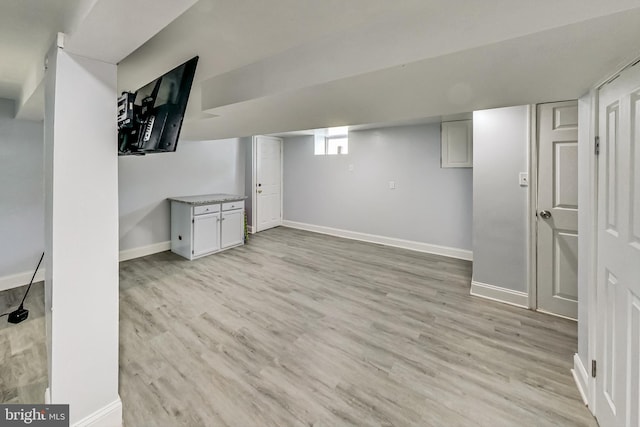 basement with light hardwood / wood-style floors