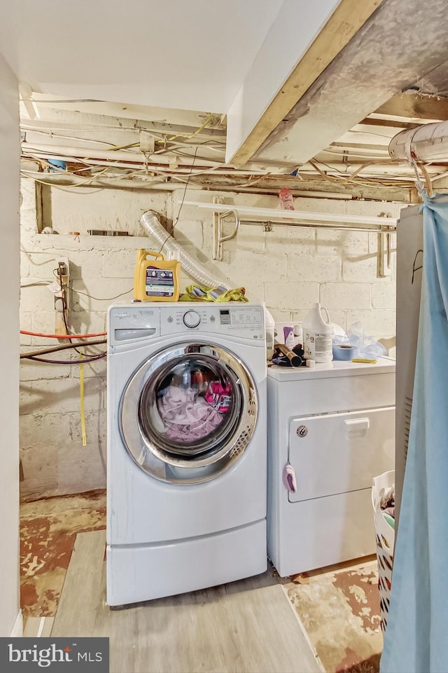 laundry room featuring light wood-type flooring and separate washer and dryer