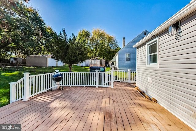 deck featuring a shed and a lawn