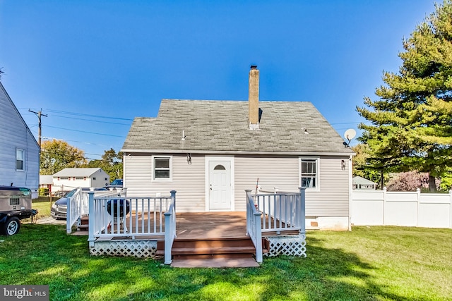 back of house featuring a lawn and a deck