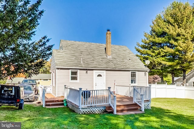 rear view of house with a yard and a wooden deck