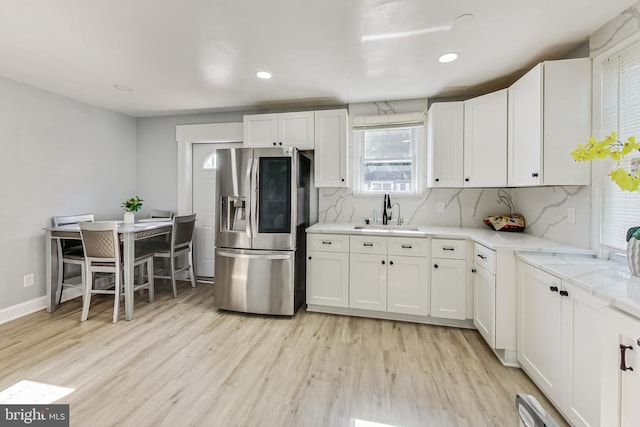 kitchen with white cabinets, stainless steel fridge with ice dispenser, and sink