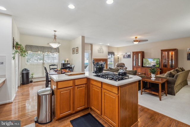 kitchen with light wood-type flooring, black gas cooktop, and a center island