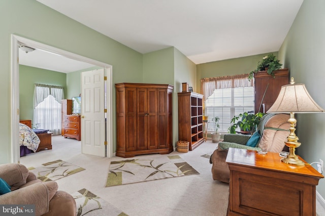 living area featuring light colored carpet and a healthy amount of sunlight