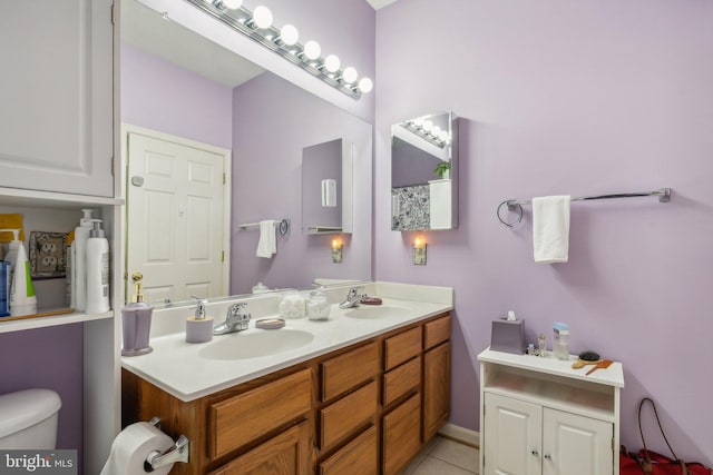 bathroom with toilet, vanity, and tile patterned floors