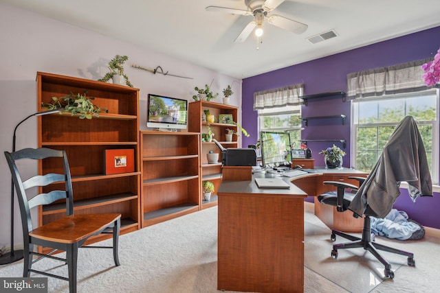 carpeted office space with ceiling fan