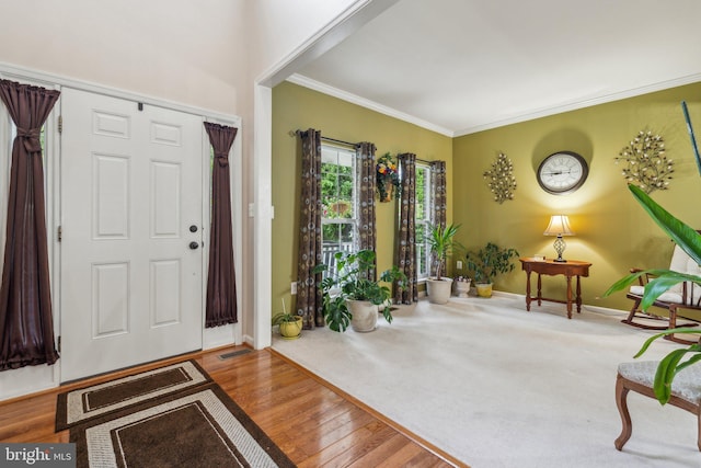 entrance foyer with ornamental molding and wood-type flooring