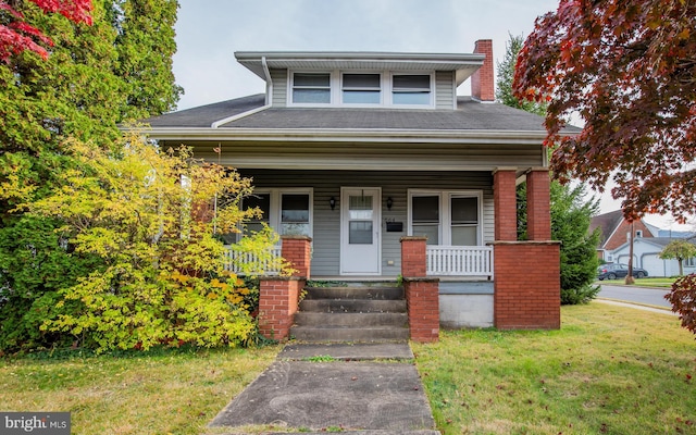 view of front of property featuring a front lawn and covered porch