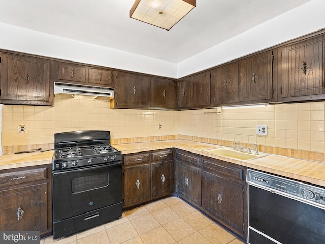 kitchen with backsplash, butcher block counters, sink, and black appliances