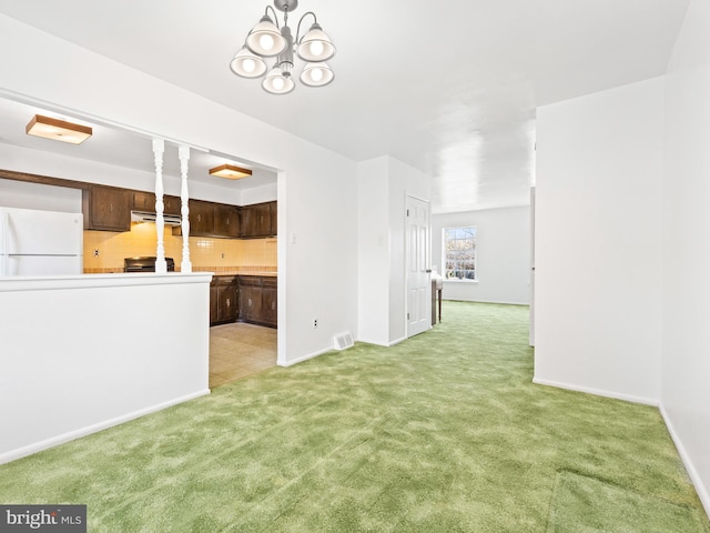 unfurnished living room with light carpet and an inviting chandelier